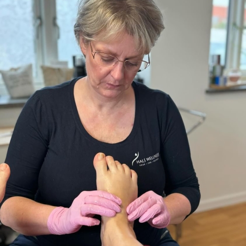 Autoriseret fodterapeut udfører fodpleje behandling i Hals
